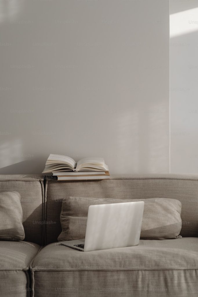 Best Books on Homesteading | BookSummaryClub a laptop computer sitting on top of a couch